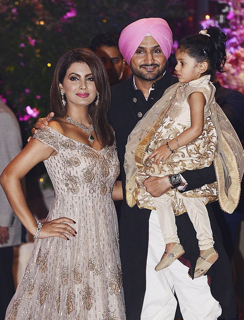 Indian Cricketer Harbhajan Singh poses for a picture with his wife and actress Geeta Basra along with their daughter Hinaya as they attend the pre-engagement party of India’s richest man and Reliance Industries Limited Chairman, Mukesh Ambanis eldest son Akash Ambani and fiancee Shloka Mehta, in Mumbai late on June 30, 2018. / AFP PHOTO / Sujit Jaiswal