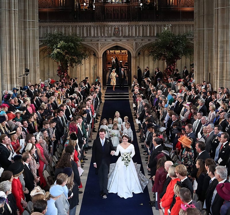 Britain’s Princess Eugenie of York (R) and Jack Brooksbank (L) walk back down the aisle hand in hand at the end of their wedding ceremony at St George’s Chapel, Windsor Castle, in Windsor, on October 12, 2018. (Photo by Danny Lawson / POOL / AFP)
