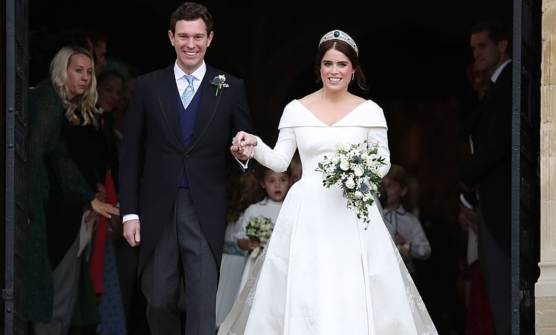 Britain’s Princess Eugenie of York (R) and her husband Jack Brooksbank (L) emerge from the West Door of St George’s Chapel, Windsor Castle, in Windsor, on October 12, 2018 after their wedding ceremony. (Photo by Steve Parsons / POOL / AFP)