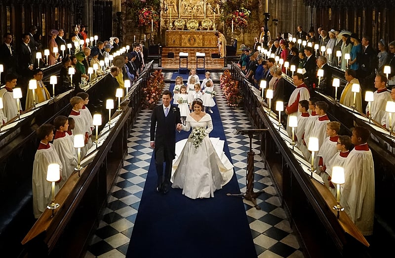 Britain’s Princess Eugenie of York (R) and Jack Brooksbank (L) walk back down the aisle of the Quire hand in hand at the end of their wedding ceremony at St George’s Chapel, Windsor Castle, in Windsor, on October 12, 2018. (Photo by Jonathan Brady / POOL / AFP)