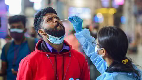 A healthworker collects swab sample  for COVID-19 test