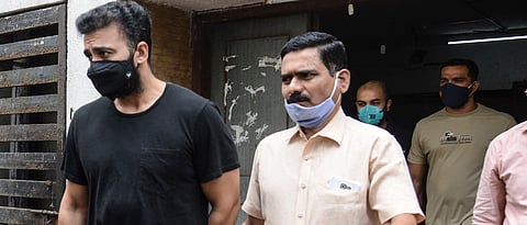 Mumbai Police's Crime Branch team escort Bollywood actress Shilpa Shetty's husband Raj Kundra (L) for allegedly producing and broadcasting pornographic films online, in Mumbai on July 27, 2021. (AFP)