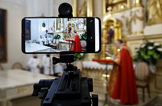 A mobile phone is used to transmit online celebrations on Good Friday