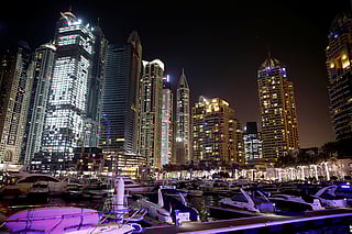 Yachts are seen at a dock at the Dubai Marina surrounded by high towers of hotels, banks and office buildings, in Dubai