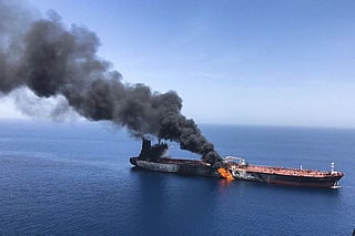 In this June 13, 2019 file photo, an oil tanker is on fire in the Gulf of Oman. Amid surging energy prices and private insurers withdrawing coverage, President Donald Trump is using America's financial and military muscle, vowing that the US Navy is ready to secure oil tankers in Hormuz "if needed". 