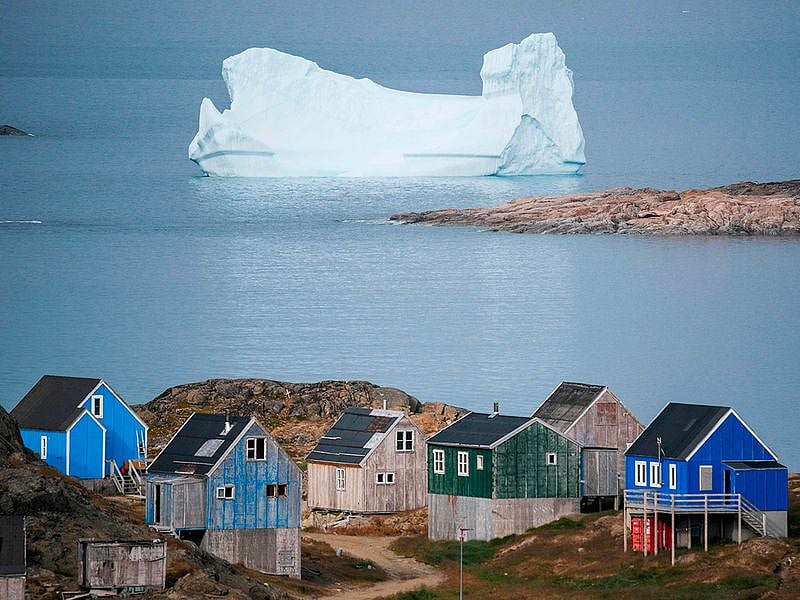 Icebergs float behind the town of Kulusuk in Greenland