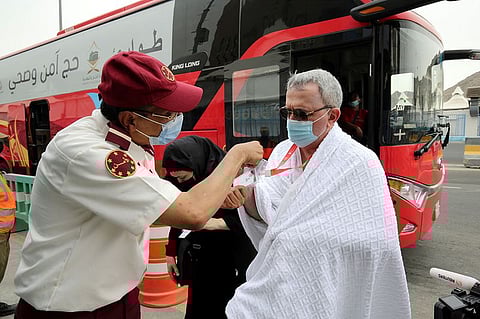 An official checks the ID and permits of pilgrims as they arrive in the Mina area for the annual Hajj, in Mecca.
