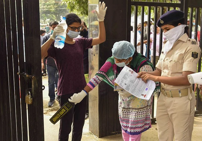 Candidates undergo a security check before entering an examination centre for the National Eligibility-Cum-Entrance Test (NEET), during unlock 4.0, in Patna.