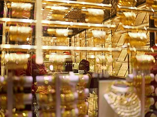 Shoppers browse gold jewellery at a Dubai souk as prices slip below Dh600 per gram for 24K, tracking a global correction in bullion after last week’s rally driven by US inflation data and rate-cut expectations.