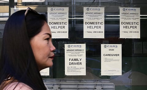 Job ads for domestic helpers and caregivers in Saudi Arabia posted outside at a recruitment agency's office in Manila.