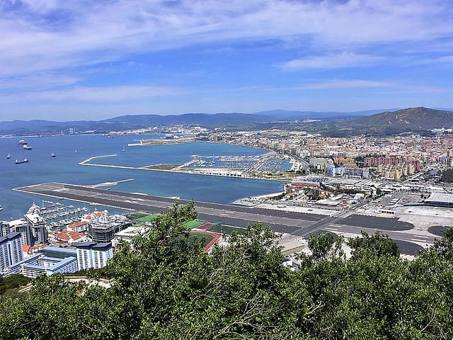 View of the Gibraltar International Airport and the harbour area. Gibraltar International Airport (formerly North Front Airport) serves as the air transport link to the city of Gibraltar. The airport is located at the centre of Gibraltar and serves around 300,000 passengers per annum. The length of the runway is 1800 metres.