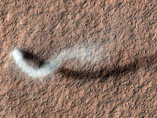 As the camera High-Resolution Imaging Science Experiment (HiRISE) pans over large swaths of Mars' surface, it occasionally discovers surprises like this towering dust devil, which was captured from 185 miles (297 kilometers) above the ground. The length of this whirlwind's shadow indicates that it was more than half a mile (800 meters) high – about the size of the United Arab Emirate's Burj Khalifa, the tallest building on Earth.