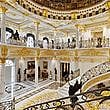 The entrance hall has grand staircases and a dome with handmade glass.