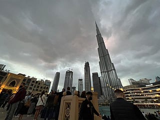 Residents and visitors visit Burj Khalifa on Friday under an overcast sky. Winds and dust reduced visibility across the UAE.