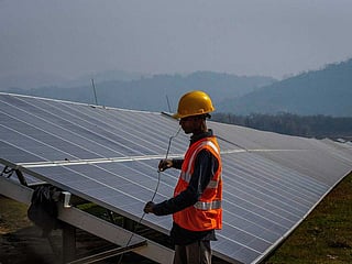 Photo shows a man works at a solar power plant in Mikir Bamuni village, Nagaon district, northeastern Assam state, India, Feb. 18, 2022.