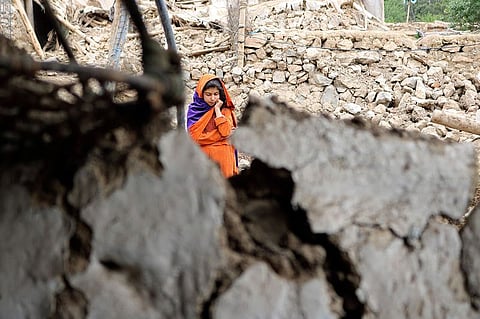 An Afghan girl stands near a house that was damaged by an earthquake in the Spera District of the southwestern part of Khost Province, Afghanistan. File photo taken on Wednesday, June 22, 2022.