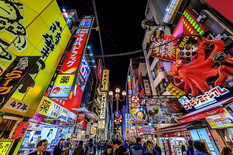 Tourist walking in night shopping street food at Dotonbori or dotombori, Dotonbori the famous destination for traveller in Shinsaibashi, Osaka City, Osaka, Japan.