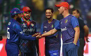 Adil Rashid congratulates former England batter and Afghanistan coach Jonathan Trott after the match between England and Afghanistan.