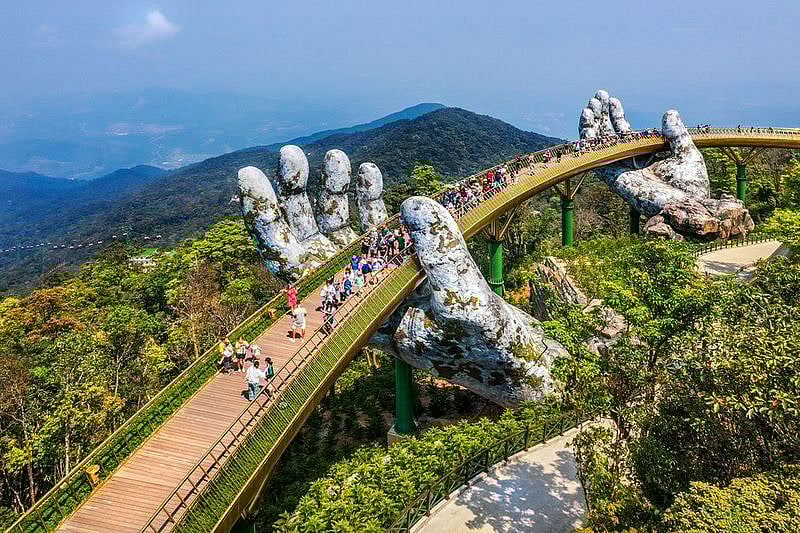 Aerial view of the Golden Bridge is lifted by two giant hands in the tourist resort on Ba Na Hill in Da Nang, Vietnam. Ba Na mountain resort is a favorite destination for tourists