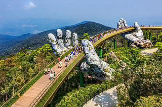 Aerial view of the Golden Bridge lifted by two giant hands in the tourist resort on Ba Na Hill in Da Nang, Vietnam. Ba Na mountain resort is one of top tourist destinations in the country.