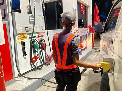 A fuel attendant fills up a customer's vehicle in the Philippines.