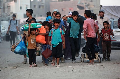 Children walk as displaced Palestinians leave an area in east Khan Yunis after the Israeli army issued a new evacuation order for parts of the city and Rafah, in the southern Gaza Strip on July 1, 2024, amid the ongoing conflict between Israel and the Palestinian Hamas militant group. 