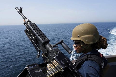 US Navy retail service specialist Artayja Stewart of Clarksville stands guard next to a machine gun aboard the USS Paul Hamilton in the Strait of Hormuz in a file picture. The widening divide between the US and Iran is playing out alongside a dangerous military buildup.