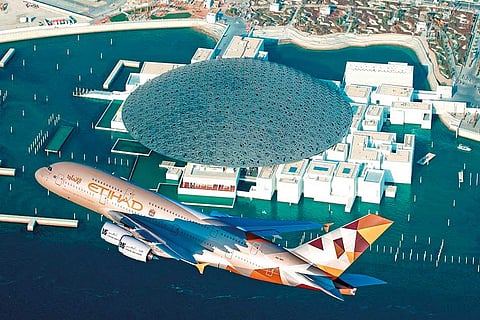 An Etihad Airways Airbus A380 sporting the airline’s ‘Facets of Abu Dhabi’ livery conducts a low-level fly-by of the Louvre Abu Dhabi during its opening.