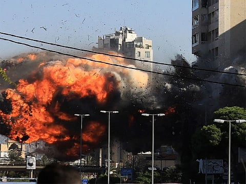 A building in Beirut's southern suburbs collapsed in a gigantic cloud of smoke and dust on Friday, an AFP photographer reported, as two strikes attributed to Israel hit the Hezbollah bastion.