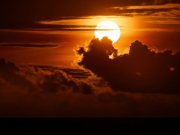 The sun sets behind the clouds in the Kerobokan district of Indonesia.
