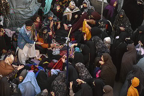 Afghan women buy clothes at a second hand market in Herat.