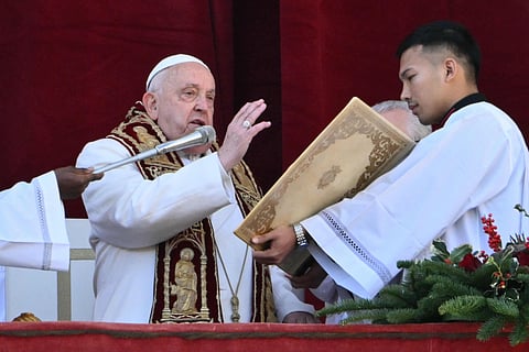 Pope Francis delivers the Urbi et Orbi message and blessing to the city and the world from  the main balcony of St. Peter's basilica as part of Christmas celebrations, at St Peter's square in the Vatican on December 25, 2024.