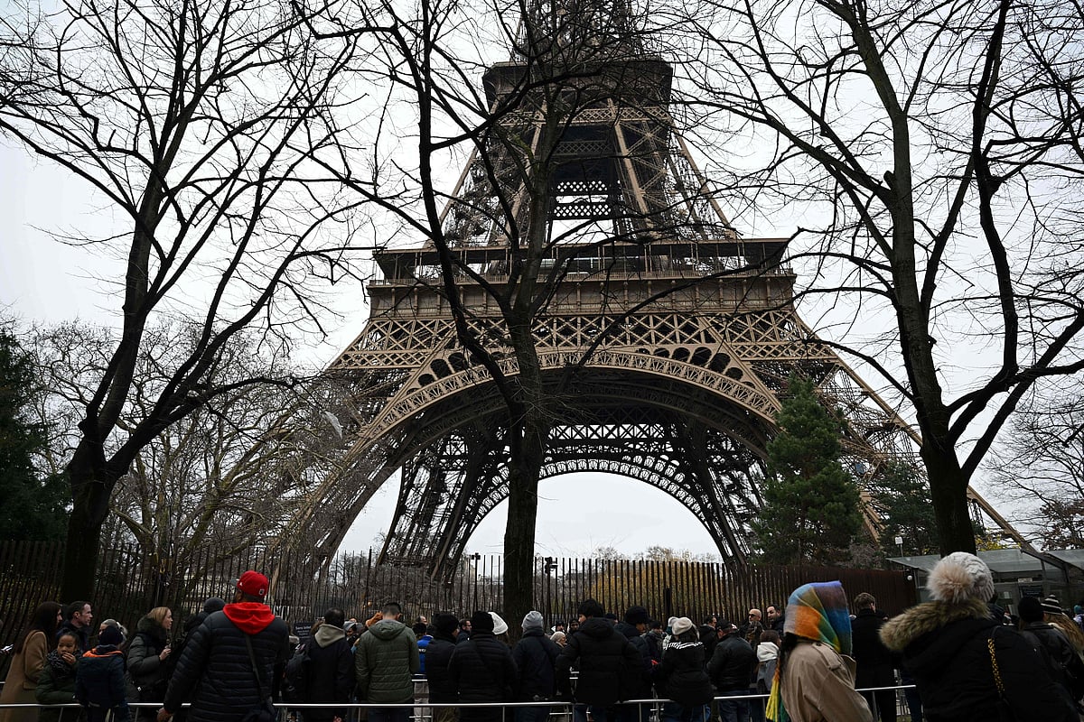 Visitors queue at the bottom of the Eiffel Tower as the site was closed and then reopened after a fire was reported in Paris, on December 24, 2024.