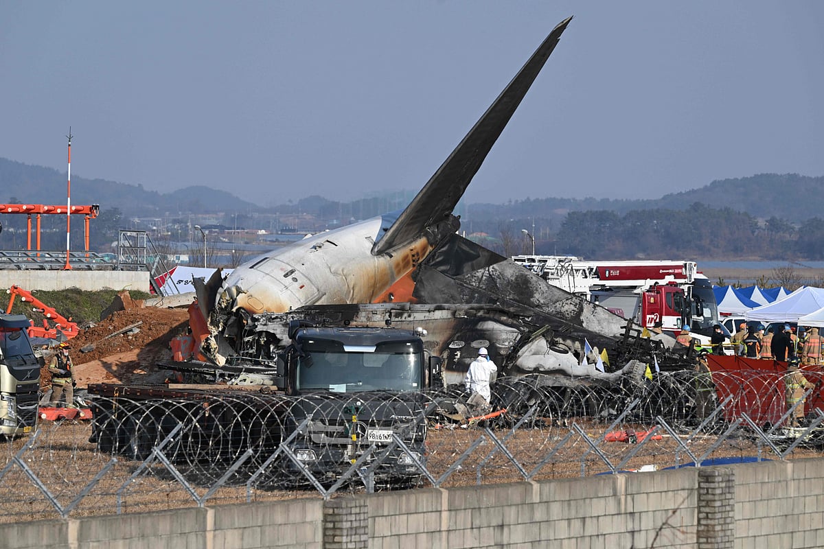 Firefighters and rescue personnel work near the wreckage of a Jeju Air Boeing 737-800 series aircraft after the plane crashed and burst into flames at Muan International Airport in South Jeolla Province.