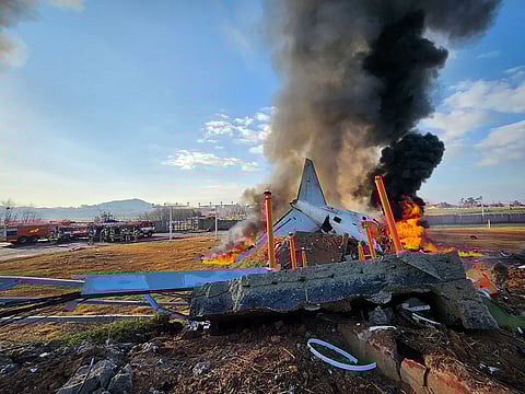 Fire and smoke rise from the tail section of a Jeju Air Boeing 737-800 series aircraft after the plane crashed and burst into flames at Muan International Airport in South Jeolla Province, southwest of Seoul on December 29, 2024. 