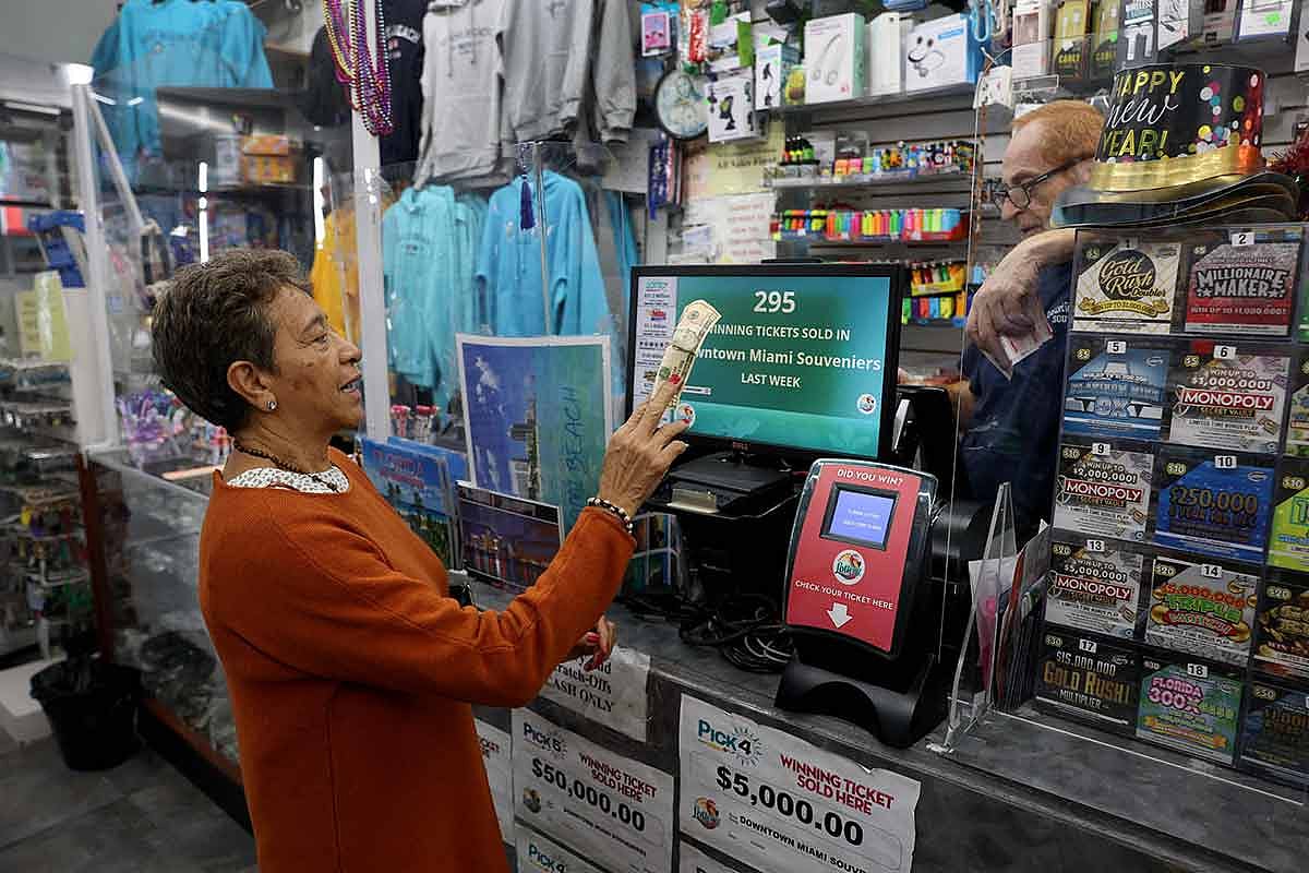 Robert Hadad sells Mega Millions lottery tickets to Miriam Rodriquez at his Downtown Miami Souvenirs store on December 26, 2024 in Miami, Florida.