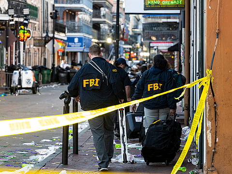 FBI investigators arrive at the scene where the white Ford F-150 pickup truck that crashed into a work lift.