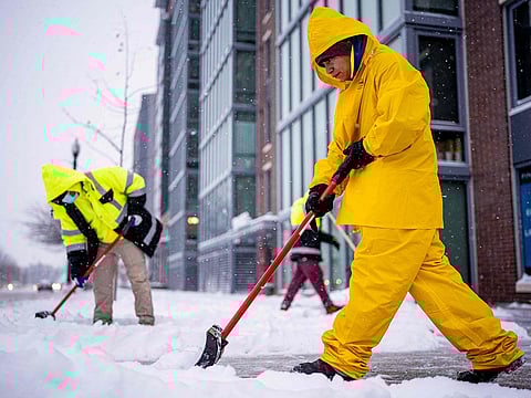 A crew shovels snow along North Capitol Street in the nation's capital in Washington, DC.