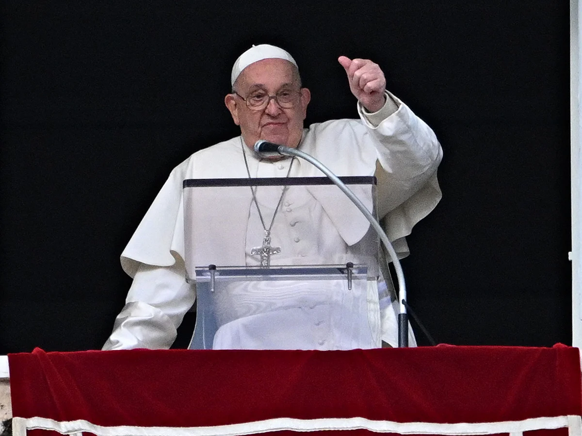 Pope Francis gestures to the crowd from the window of the Apostolic Palace overlooking St Peter's Square during the Epiphany Angelus prayer, in the Vatican, on January 6, 2025. 