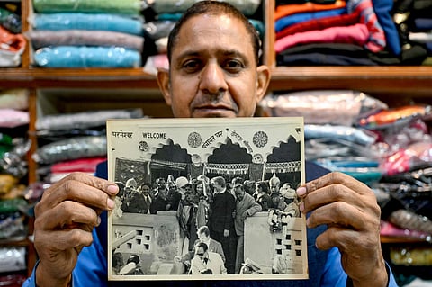 Resident Rajiv Kumar shows a photograph at his shop near Carterpuri village in Gurgaon on January 7, 2025, picturing late Carter and his wife Eleanor Rosalynn Carter during their visit to the eponymous village in 1978.  
