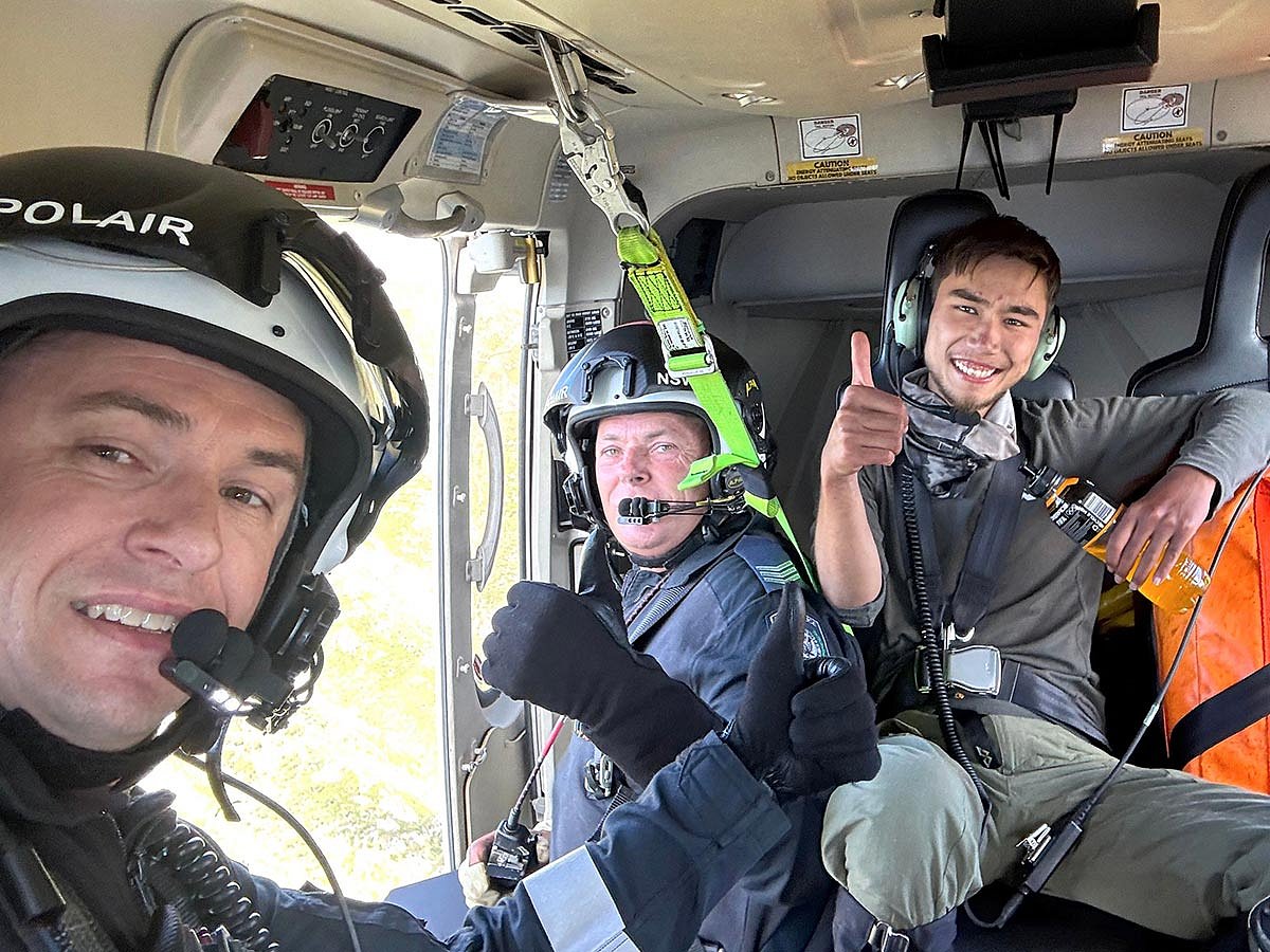 Police officers reacting after they rescued 23-year-old university student Hadi Nazari (R), who was lost in Australia's alpine wilderness and survived for almost two weeks on foraged berries and scavenged muesli bars, police said.  