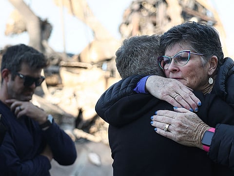  A supporter hugs Rev. John Shaver (2nd L) after he visited the remains of Community United Methodist Church, where he is pastor, as wildfires cause damage and loss through Los Angeles County on January 10, 2025 in Pacific Palisades, California.  