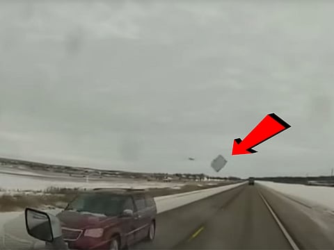 A flying ice chunk flew off the top of a van into the truck's windshield.