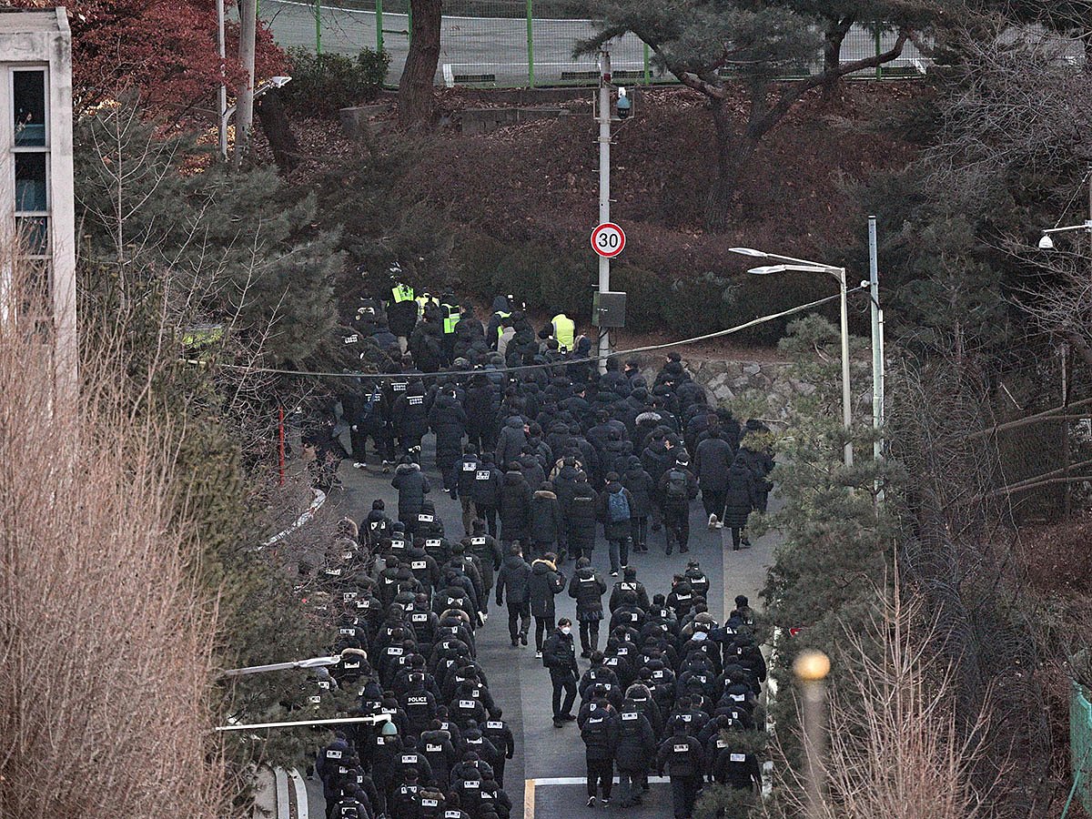 Police officers enter the compound of the presidential residence of impeached South Korea President Yoon Suk Yeol in Seoul.