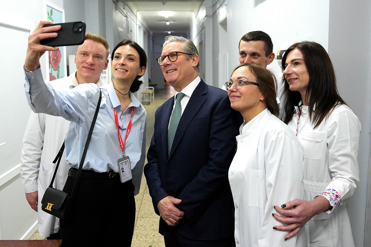 Britain's Prime Minister Keir Starmer poses for a selfie with staff members during a visit to a hospital in Kyiv on January 16, 2025.  