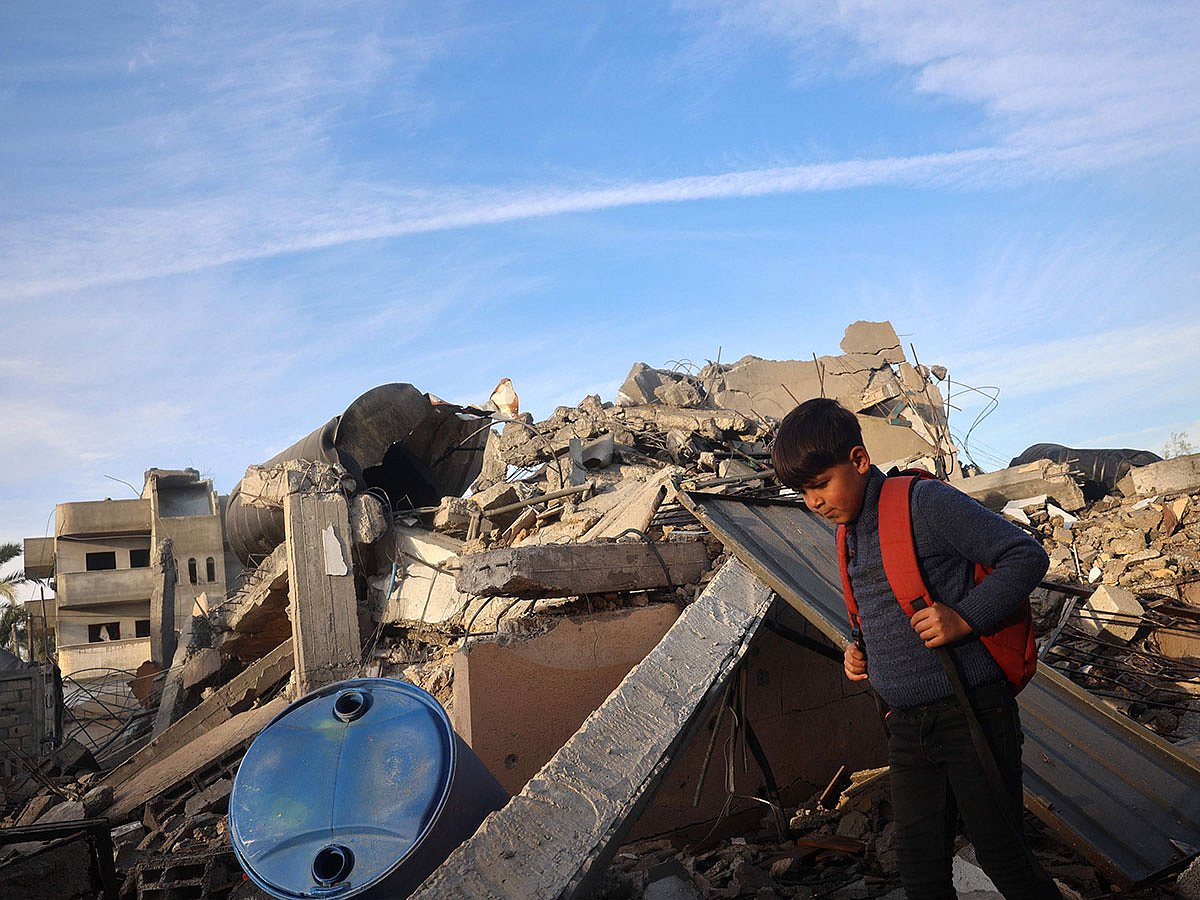 A boy walks past a destroyed building in the aftermath of an Israeli strike at Deir el-Balah in the central Gaza Strip.