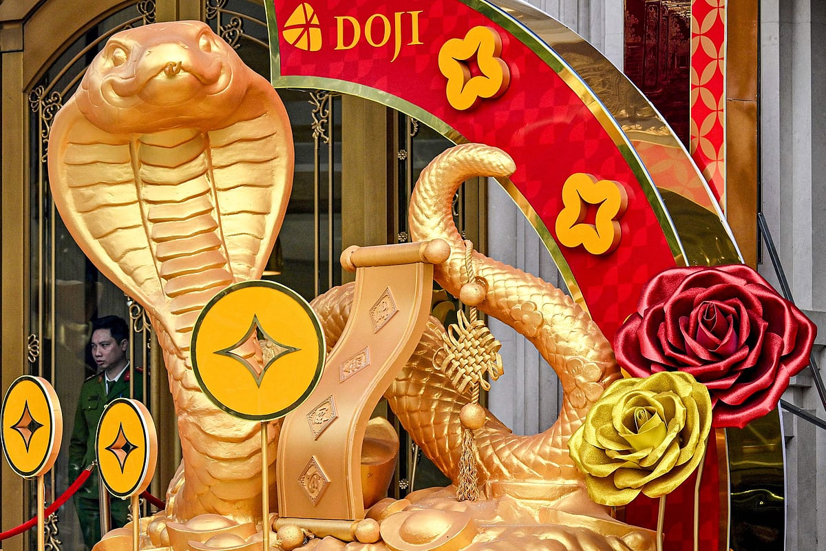 A police officer (L) stands behind snake decorations displayed ahead of the upcoming Chinese New Year, marking the Year of the Snake, in Hanoi on January 15, 2025.