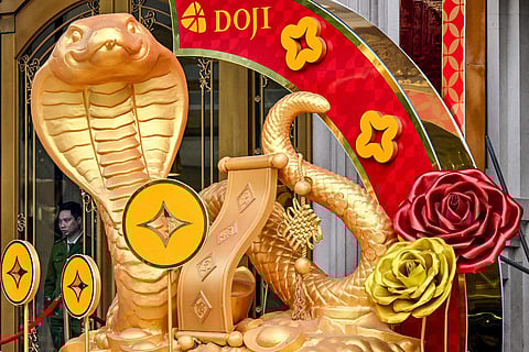 A police officer (L) stands behind snake decorations displayed ahead of the upcoming Chinese New Year, marking the Year of the Snake, in Hanoi on January 15, 2025.