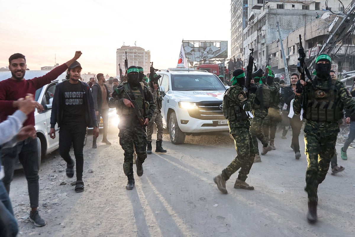 Fighters of the Ezzedine Al Qassam Brigades, Hamas's armed wing, escort vehicles of the International Committee of the Red Cross (ICRC) in Saraya Square in western Gaza City on January 19, 2025.  