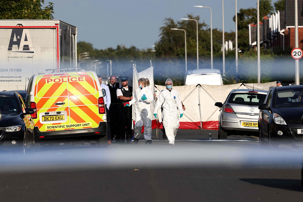 Police officers and forensic personnel put up a fence on Hart Street in Southport, northwest England, on July 29, 2024, following a knife attack.  